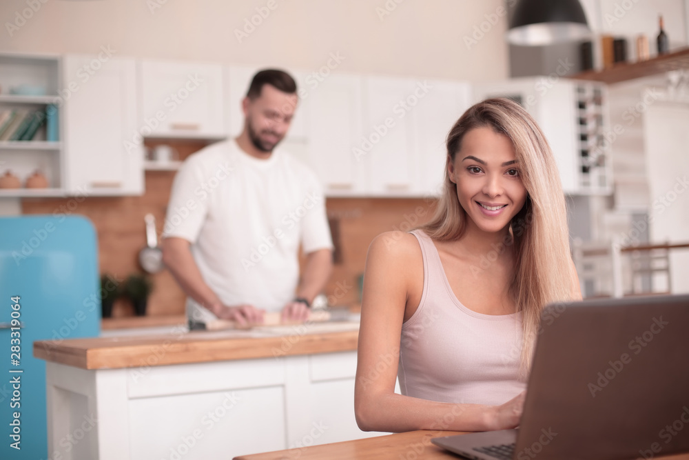young female freelancer working on laptop in kitchen young female freelancer working on laptop in kitchen