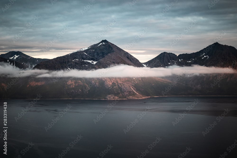 Fototapeta premium Fjord landscape in Norway with mountains and sea in the golden hour