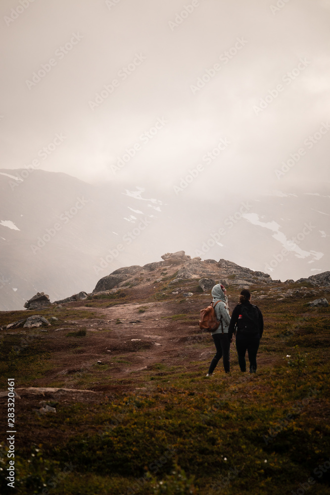 Girls hiking down to valley from a mountain in Northern Norway