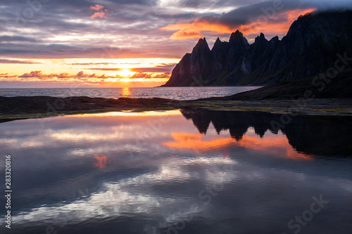 Reflection in a rockpool of impressive Oksen Mountain range at very colorful sunset, Tungeneset, Senja, Norway © sg-naturephoto.com 
