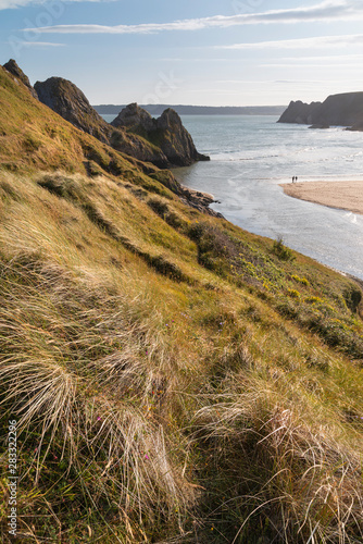 Beautiful peaceful Summer evening sunset beach landscape image at Three Cliffs Bay in South Wales