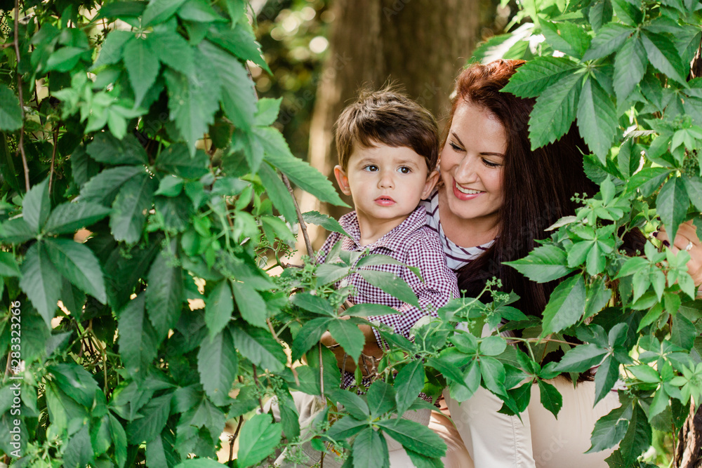 Happy mother with cute little boy having fun outdoors. Cheerful woman playing with her son in park. Joyful motherhood. Happy mother with cute little boy having fun outdoors. Cheerful woman playing with her son in park. Joyful motherhood.