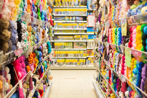 Shelves with colorful yarn balls at knitting store. Shop Needlework, counters with colored yarn. Shopping wool balls