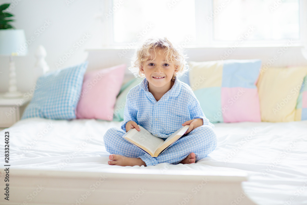 Child reading book in bed. Kids read in bedroom. Child reading book in bed. Kids read in bedroom.