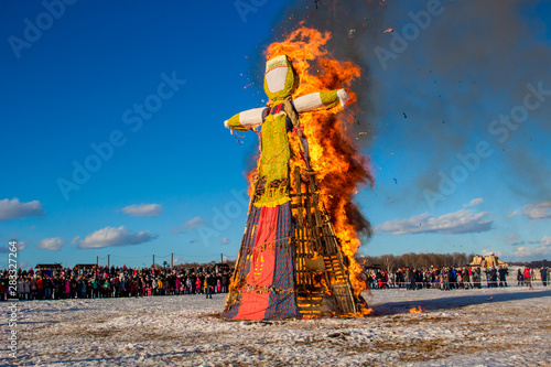 Etnomir, Russia - March 2019: Burning a big stuffed. Russian spring holiday Maslenitsa (Maslenica) photo