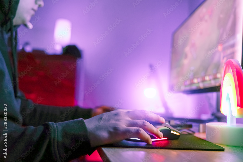Young gamer playing video game wearing gaming mouse. Gamer concentrated using computer for the best playing game. New technology game trends and entertainment concept - Image Young gamer playing video game wearing gaming mouse. Gamer concentrated using computer for the best playing game. New technology game trends and entertainment concept - Image