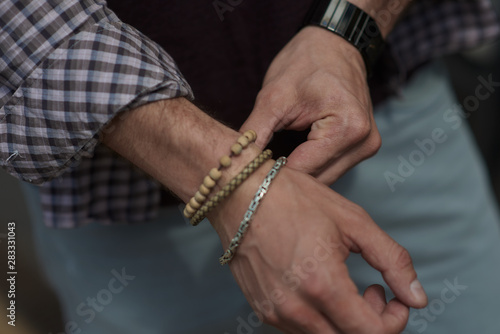 straightens the bracelet with his hand