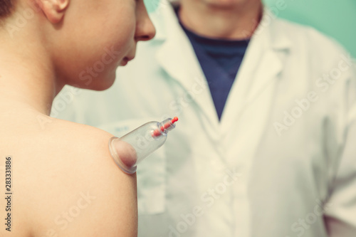 healing bloodletting hijama or phlebotomy hajam master conducts cupping therapy on a young man