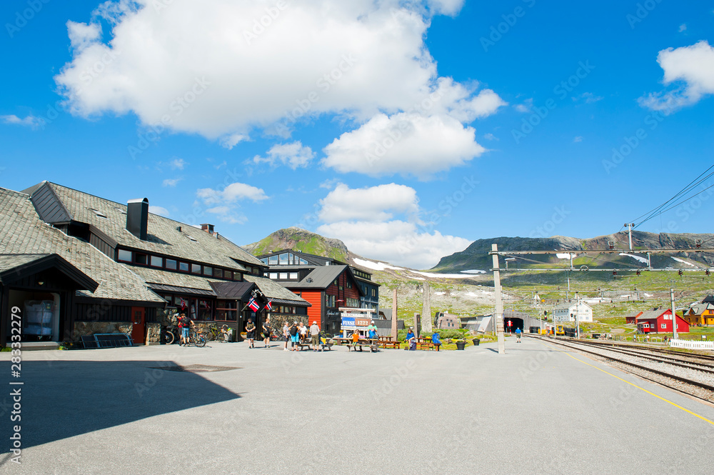 FINSE, NORWAY - JULY 28, 2019: Tourists, Hotel Finse 1222 and railway station in Finse FINSE, NORWAY - JULY 28, 2019: Tourists, Hotel Finse 1222 and railway station in Finse