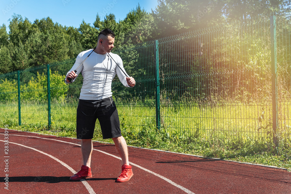 athletic man at the stadium with a skipping rope. Healthy lifestyle. Sport activities on the street athletic man at the stadium with a skipping rope. Healthy lifestyle. Sport activities on the street