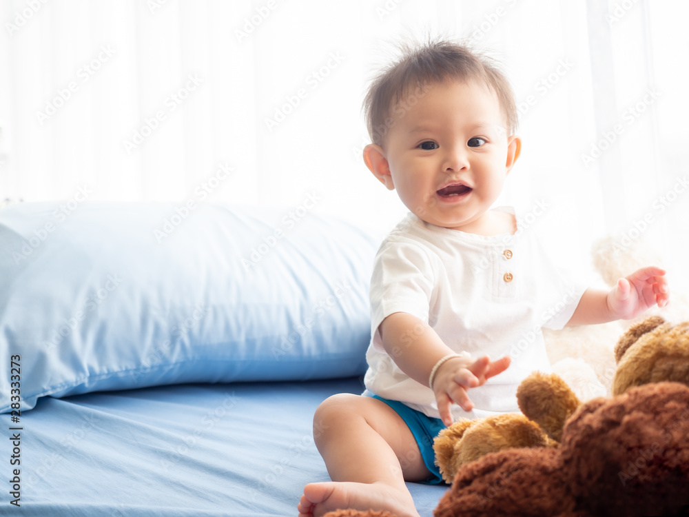 Portrait happy baby boy is sitting on the bed in the room. Asian baby boy is waiting a doctor on the patient bed in the hospital. Portrait happy baby boy is sitting on the bed in the room. Asian baby boy is waiting a doctor on the patient bed in the hospital.