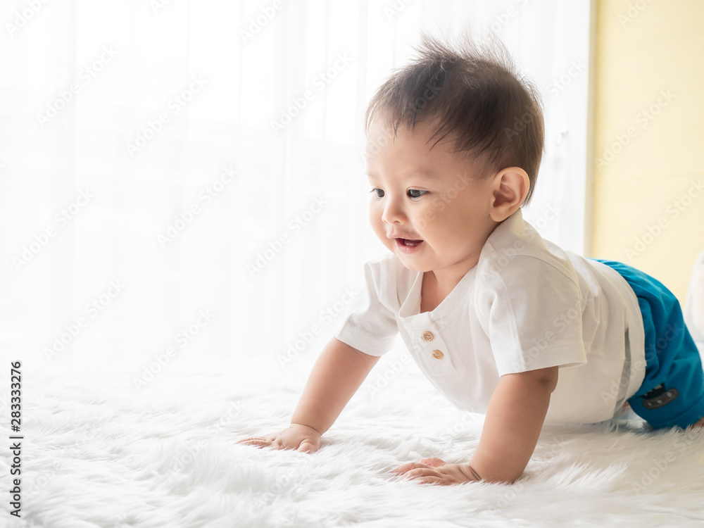 Portrait happy baby boy is crawling on white carpet in the room. Asian baby boy is crawling and smiling. Portrait happy baby boy is crawling on white carpet in the room. Asian baby boy is crawling and smiling.