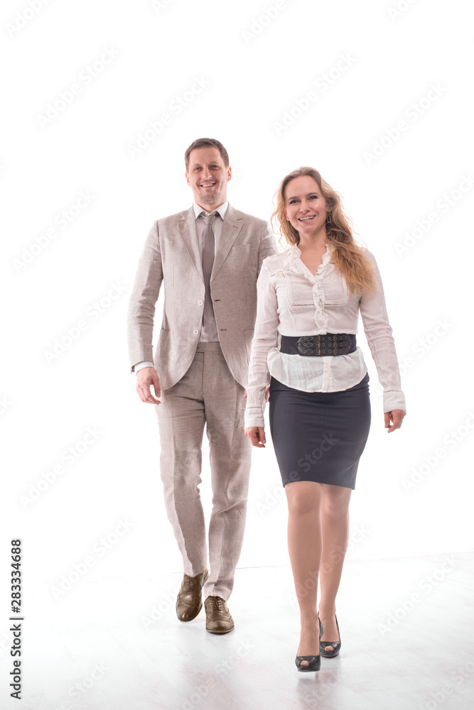 Two young employees or a businessman, a man and a woman, confidently purposefully walk along the corridor in the office. Teamwork concept, young entrepreneurs, confident youth Two young employees or a businessman, a man and a woman, confidently purposefully walk along the corridor in the office. Teamwork concept, young entrepreneurs, confident youth