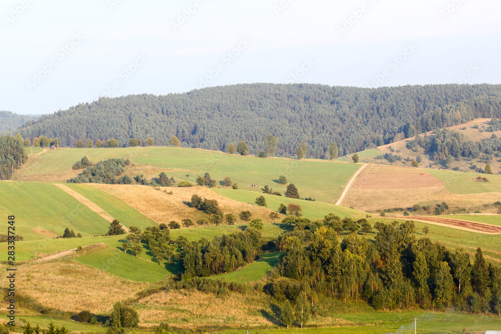 View of fields in Beskidy Mountains at sunset