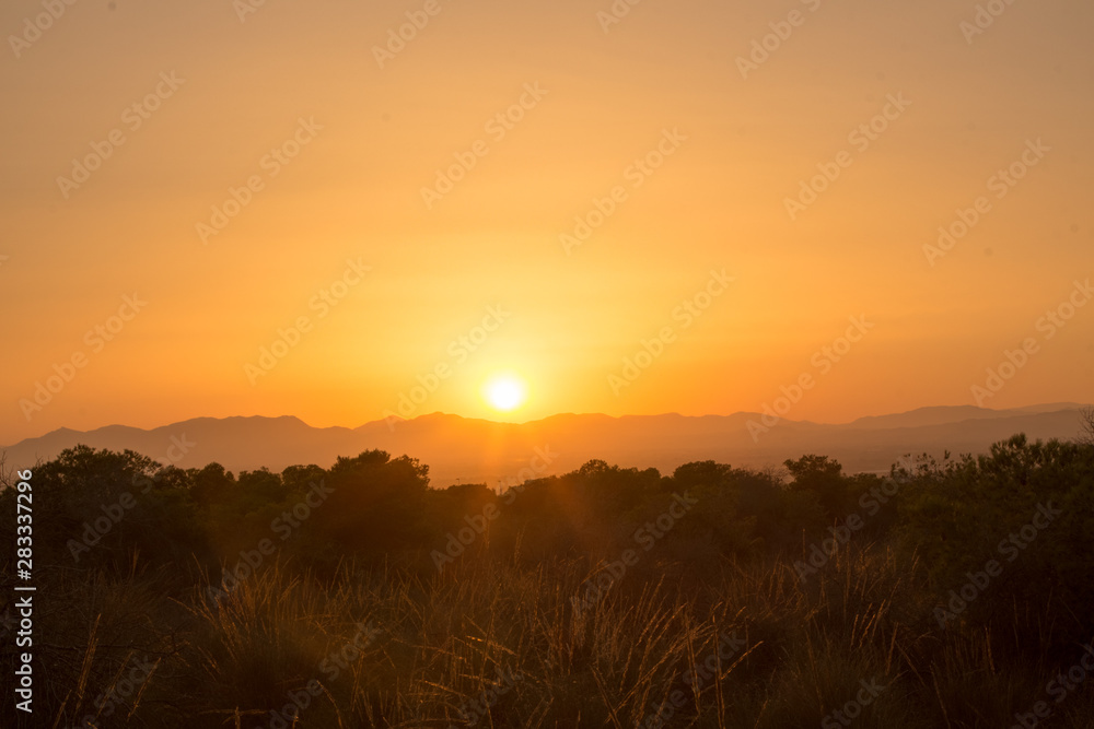 HDR image of a sunset behind the mountains during a warm Summer evening in Augsut seen over Alicante City 