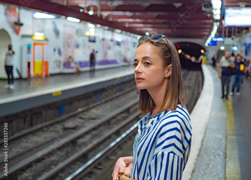 Young French woman waits for the subway train in Paris