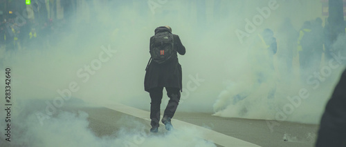 Homme s'enfonçant dans le brouillard lacrymogène lors d'une manifestation. photo