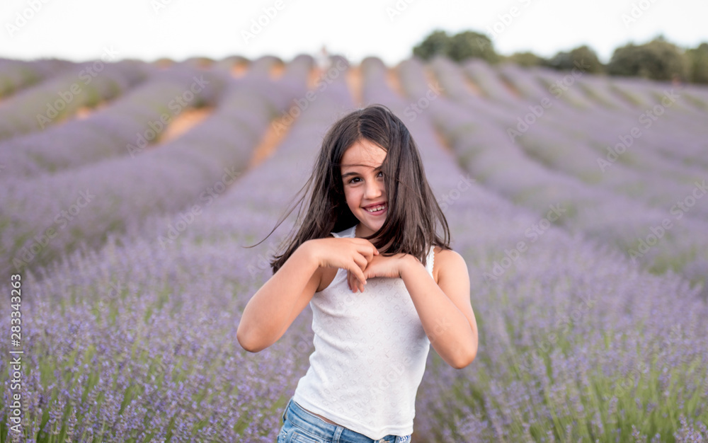 Pretty little girl in a field of lavender flowers