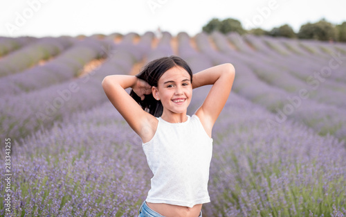 Fototapeta Naklejka Na Ścianę i Meble -  Pretty little girl in a field of lavender flowers