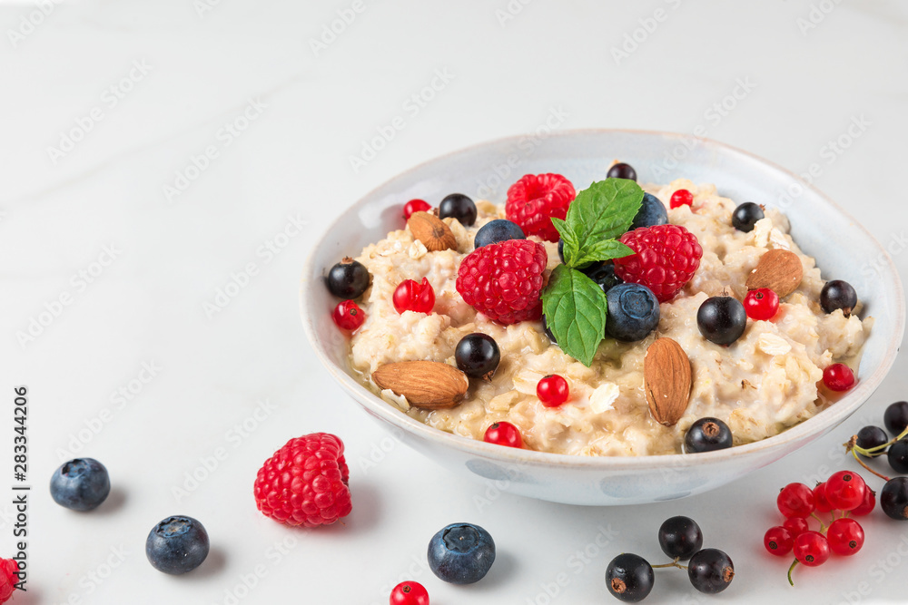 healthy homemade oatmeal porridge with berries, nuts and mint. diet breakfast food concept healthy homemade oatmeal porridge with berries, nuts and mint. diet breakfast food concept