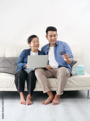 Asian man teaching his mother for shopping online, modern lifestyle concept.