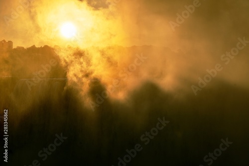 The sun attempts to break through the waterfall mist