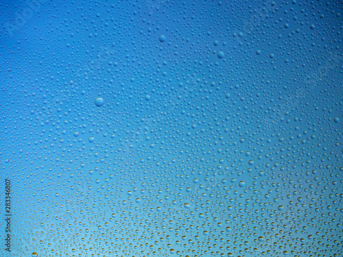Water droplets on the glass with a colored background. Drops of water.