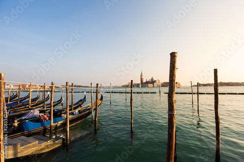 Gondolas in Venice sunset view with San Giorgio Maggiore church from San Marco square in Italy. Intentional motion blur.