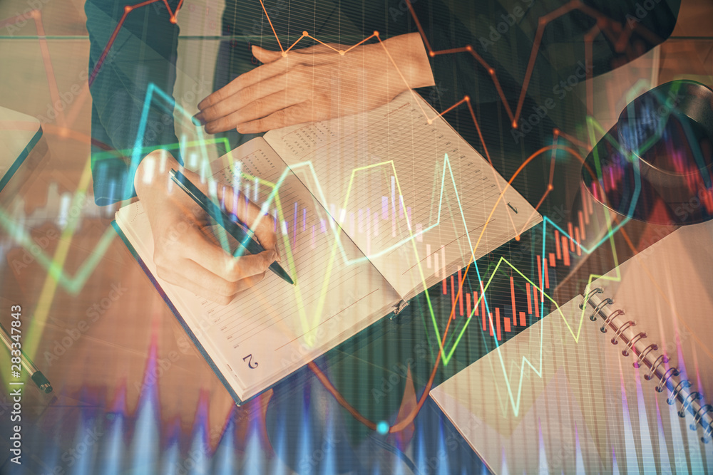 Forex chart hologram on hand taking notes background. Concept of analysis. Multi exposure Forex chart hologram on hand taking notes background. Concept of analysis. Multi exposure