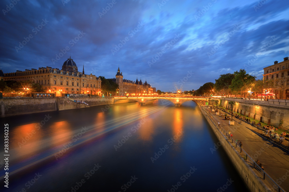 La conciergerie de Paris de nuit avec le pont Notre-Dame et la Seine