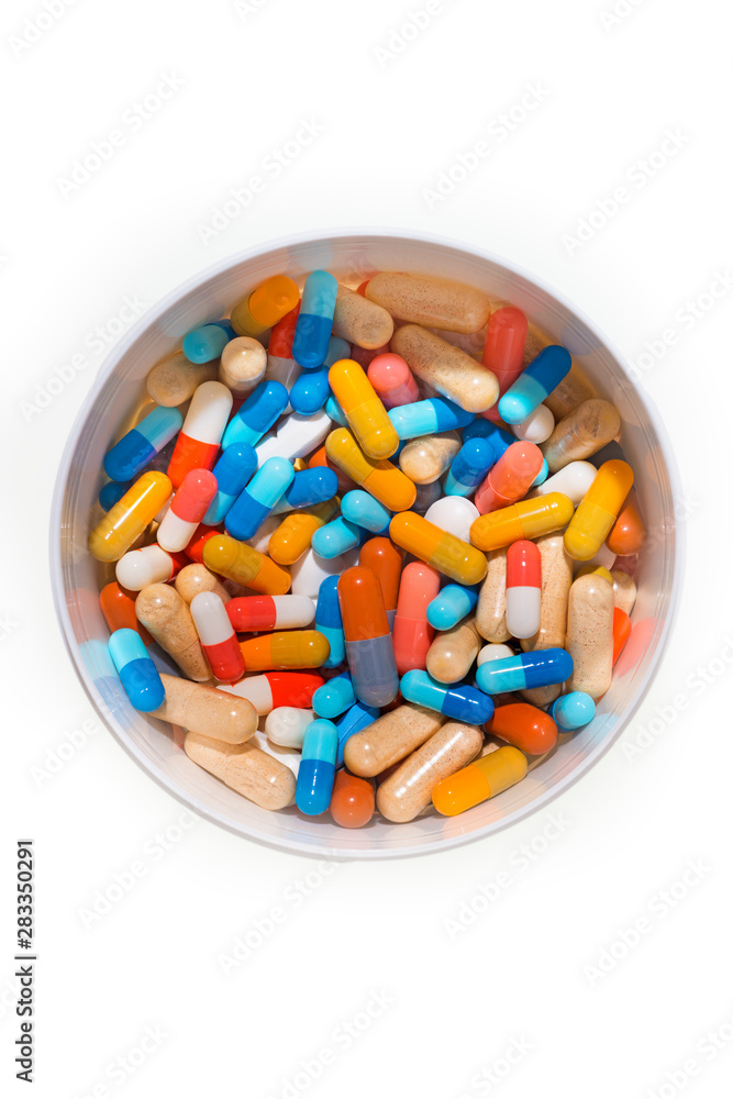 Container with a collection of colorful pills on a white background Container with a collection of colorful pills on a white background