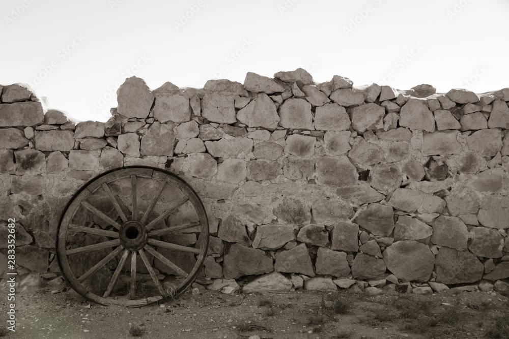 Rustic wagon wheel and stone wall