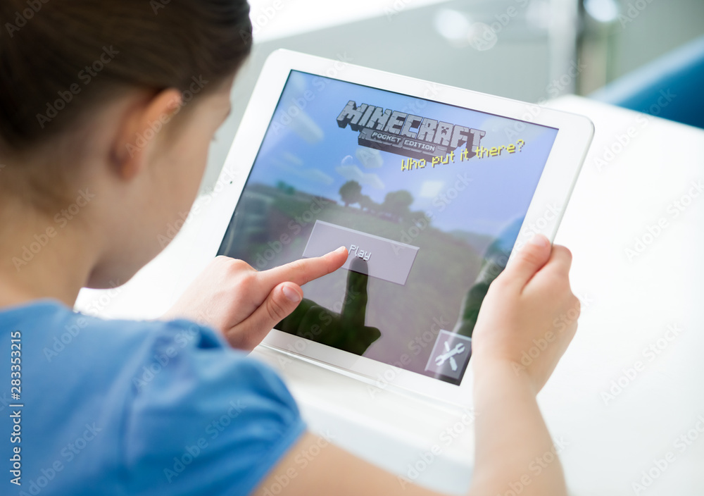 Fototapeta premium KIEV, UKRAINE - MAY 21, 2014: A girl starts playing Minecraft game on an Apple iPad Air digital tablet.