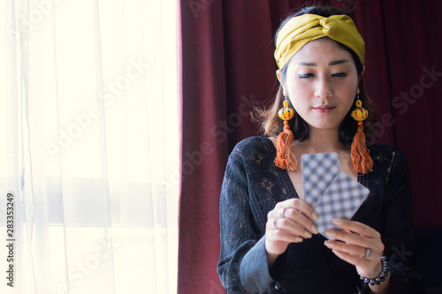 Tableau sur toile A beautiful gypsy or bohemian woman is reading tarot cards