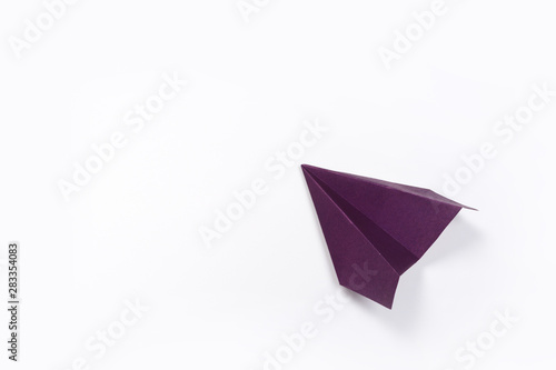 Violet paper airplane isolated on white background. top view