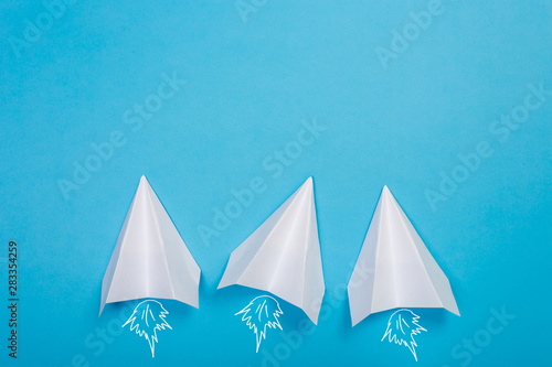 white paper airplane on a navy paper background © Nana_studio