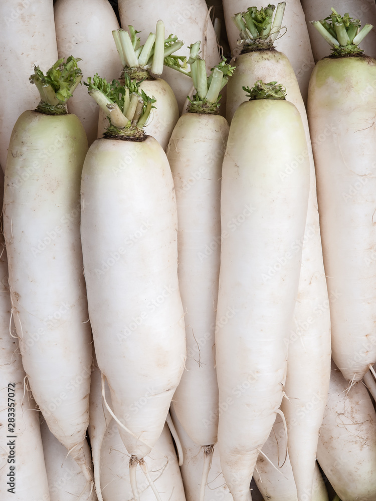 Fresh radish daikon lie in a box, top view. Fresh radish daikon lie in a box, top view.