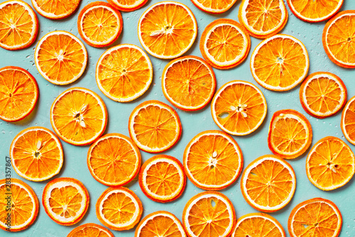 Bright dry orange slices on the blue table