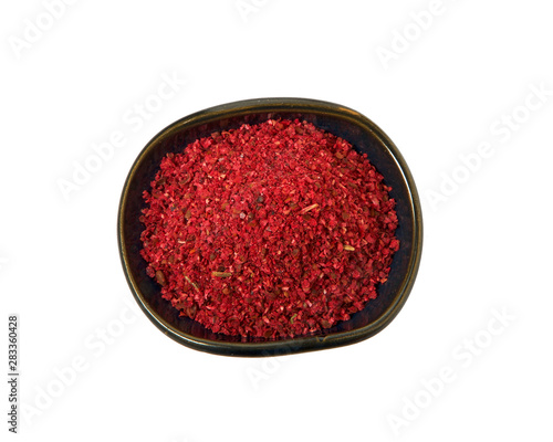 Ground red pepper in a bowl isolated on a white background. View from above.