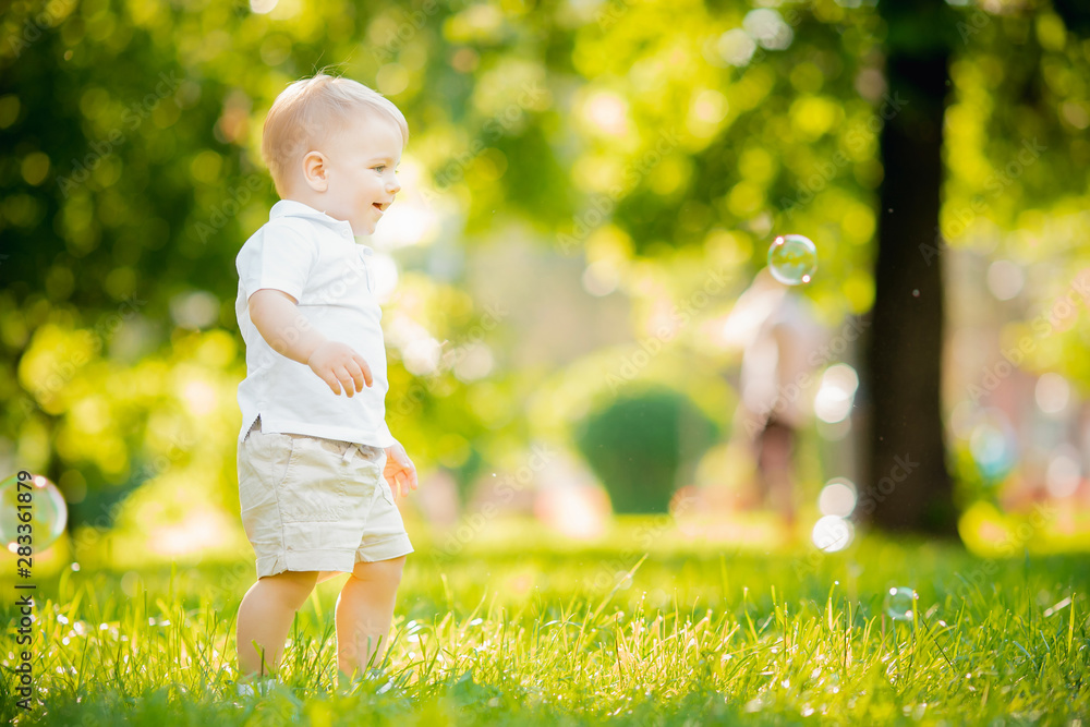 Portrait child boy crawling takes first step, trying to stand up in park Sunlight Portrait child boy crawling takes first step, trying to stand up in park Sunlight