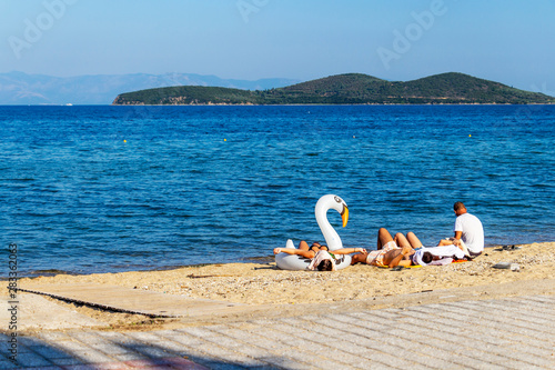 Four sunbathing tourists at a Nea Peramos beach, Municipality of Pangaio, Kavala Region, North Greece photo