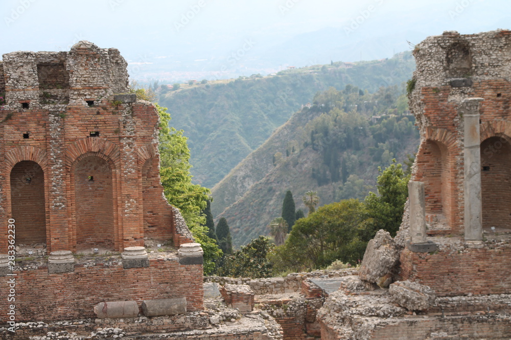 Scorcio sul paesaggio siciliano con resti archeologici di un teatro antico