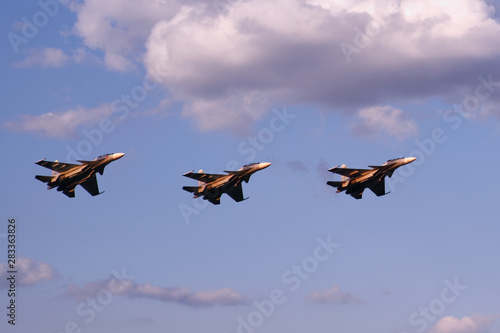 Three air fighters against sunset sky and clouds