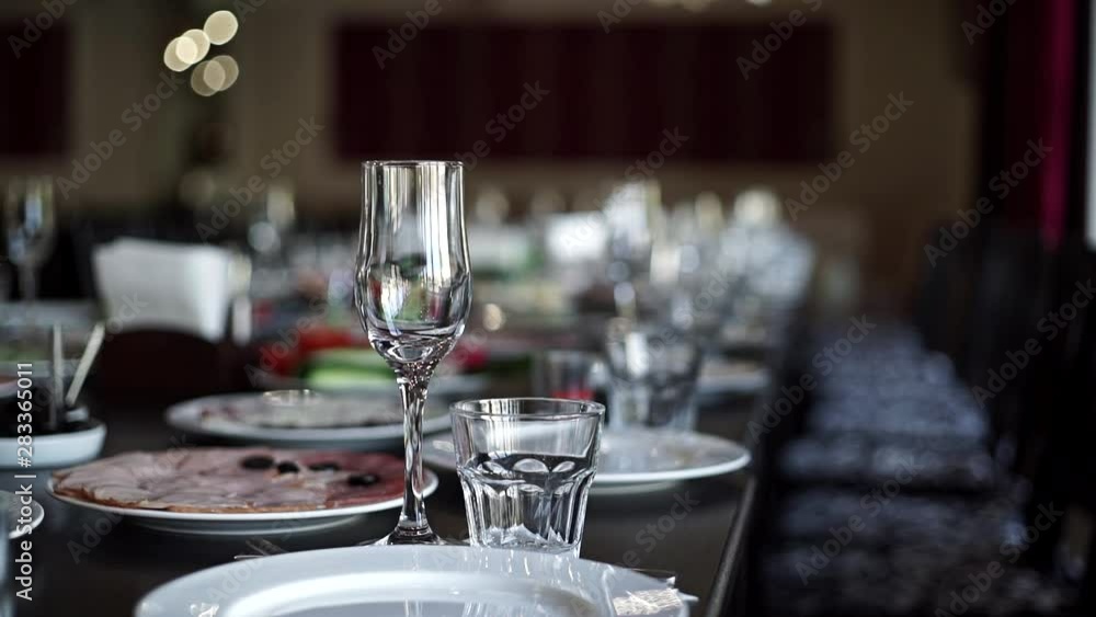 An empty wine glass is on the holiday table. Beautiful festive table setting An empty wine glass is on the holiday table. Beautiful festive table setting