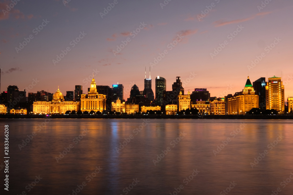 Beautiful sunset of The Bund in Shanghai. Golden illuminated western buildings on the bank of Huangpu River. Long exposure peaceful river. Wide angle Beautiful sunset of The Bund in Shanghai. Golden illuminated western buildings on the bank of Huangpu River. Long exposure peaceful river. Wide angle