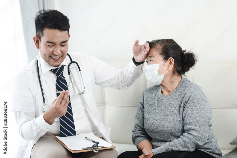 Asian doctor checking up his patient old woman in office.