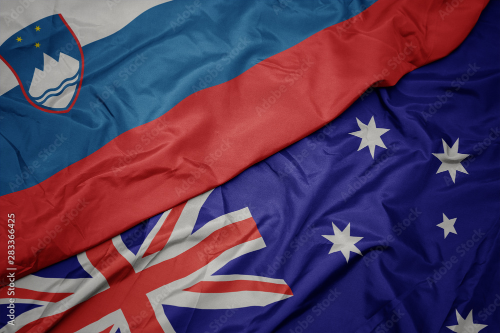 waving colorful flag of australia and national flag of slovenia. waving colorful flag of australia and national flag of slovenia.