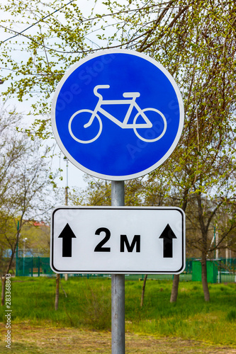 The road sign of bicycle lane in the city with the information table "Start after 2 meters"