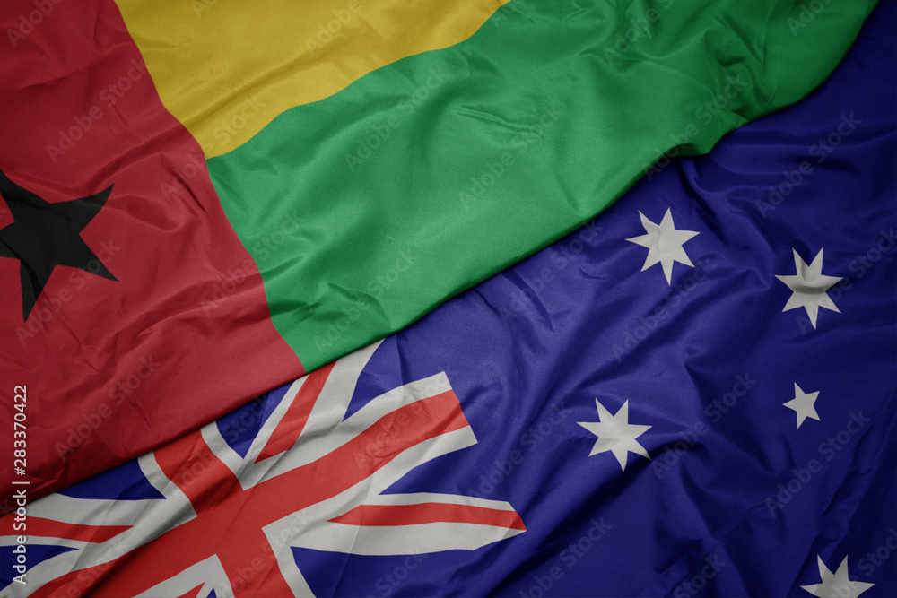 waving colorful flag of australia and national flag of guinea bissau. waving colorful flag of australia and national flag of guinea bissau.