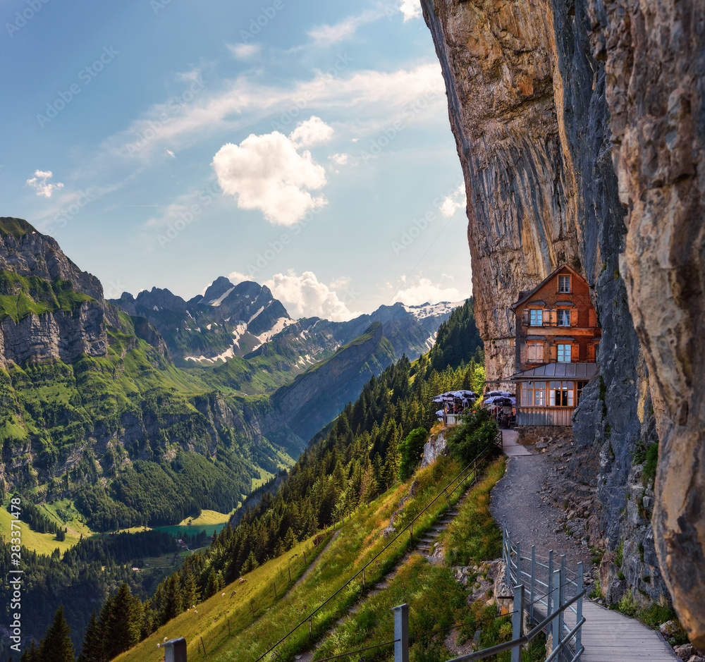 Swiss Alps and a restaurant under a cliff on mountain Ebenalp in Switzerland Swiss Alps and a restaurant under a cliff on mountain Ebenalp in Switzerland